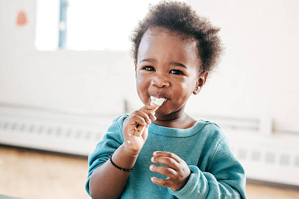 Enfant qui mange du fromage frais sur une cuillère